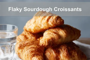 Flaky Sourdough Croissants on white napkin with water, clean and warm setup