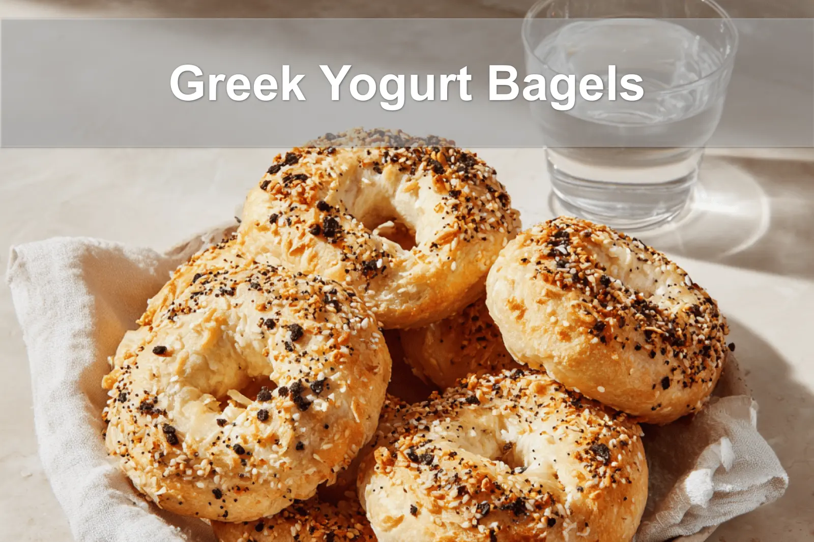 Golden-brown Greek Yogurt Bagels with seasoning, soft interior, and melted ingredients on a bright setup.