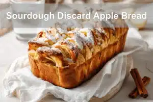 Sourdough Discard Apple Bread with cinnamon, apples, and powdered sugar, warm golden tones.