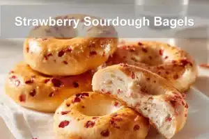 Strawberry Sourdough Bagels on white napkin with water glass beside them