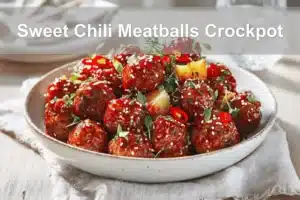 Sweet Chili Meatballs Crockpot in white dish with herbs, pineapple, and a glass of water