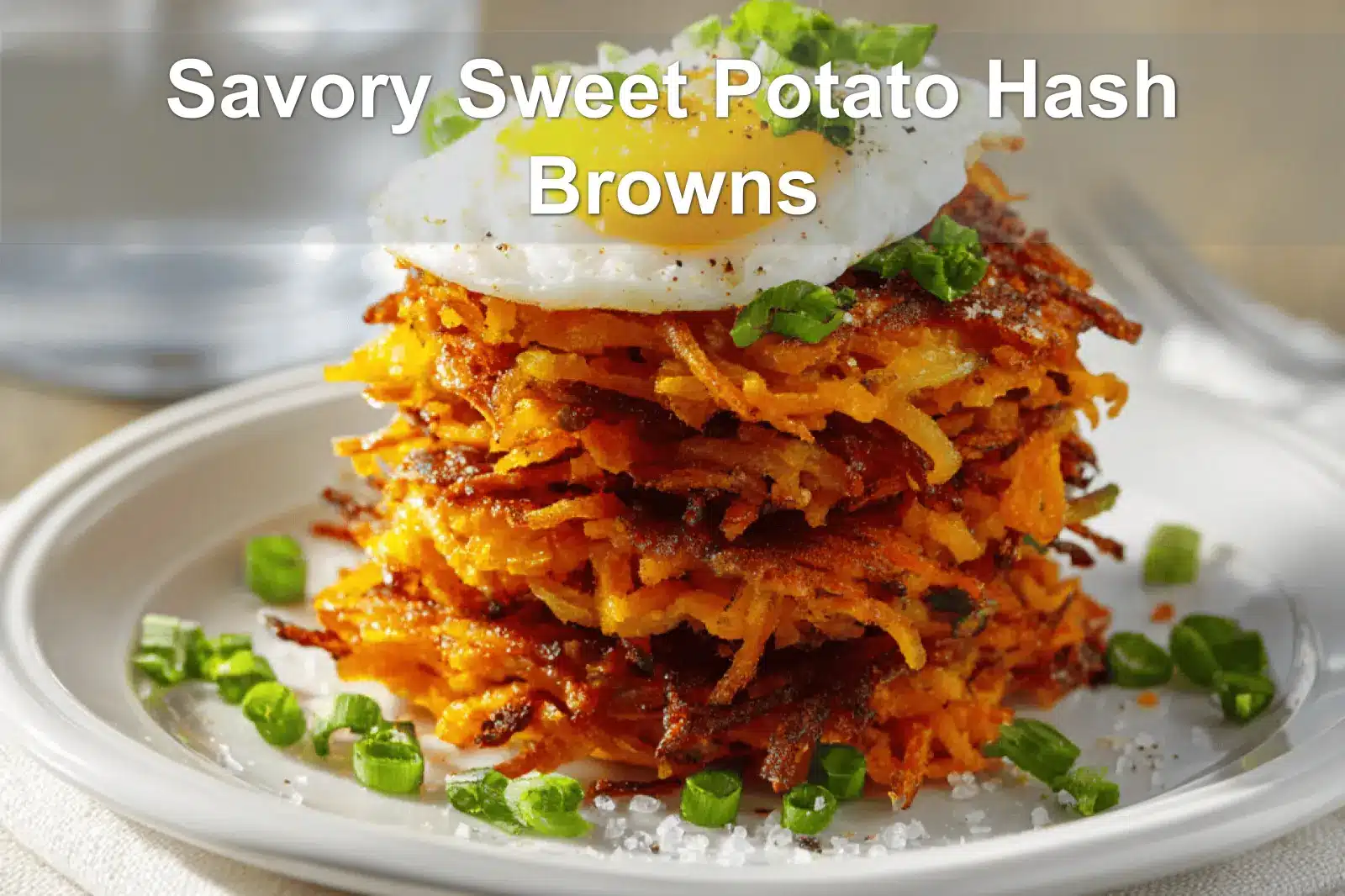 Savory Sweet Potato Hash Browns on white napkin with glass of water and golden crust