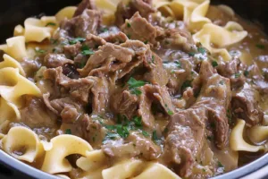 Crock Pot Beef and Noodles Easy Comforting Weeknight Dinner CROCK POT BEEF AND NOODLES centered hero view, clean and uncluttered