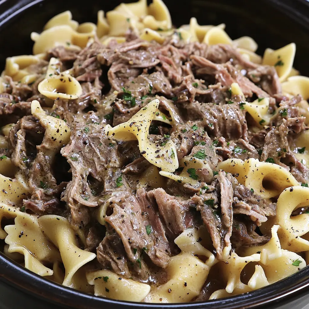 Crock Pot Beef and Noodles Easy Comforting Weeknight Dinner 3 Crock Pot Beef and Noodles in a deep bowl with tender shredded beef and wide egg noodles in rich gravy